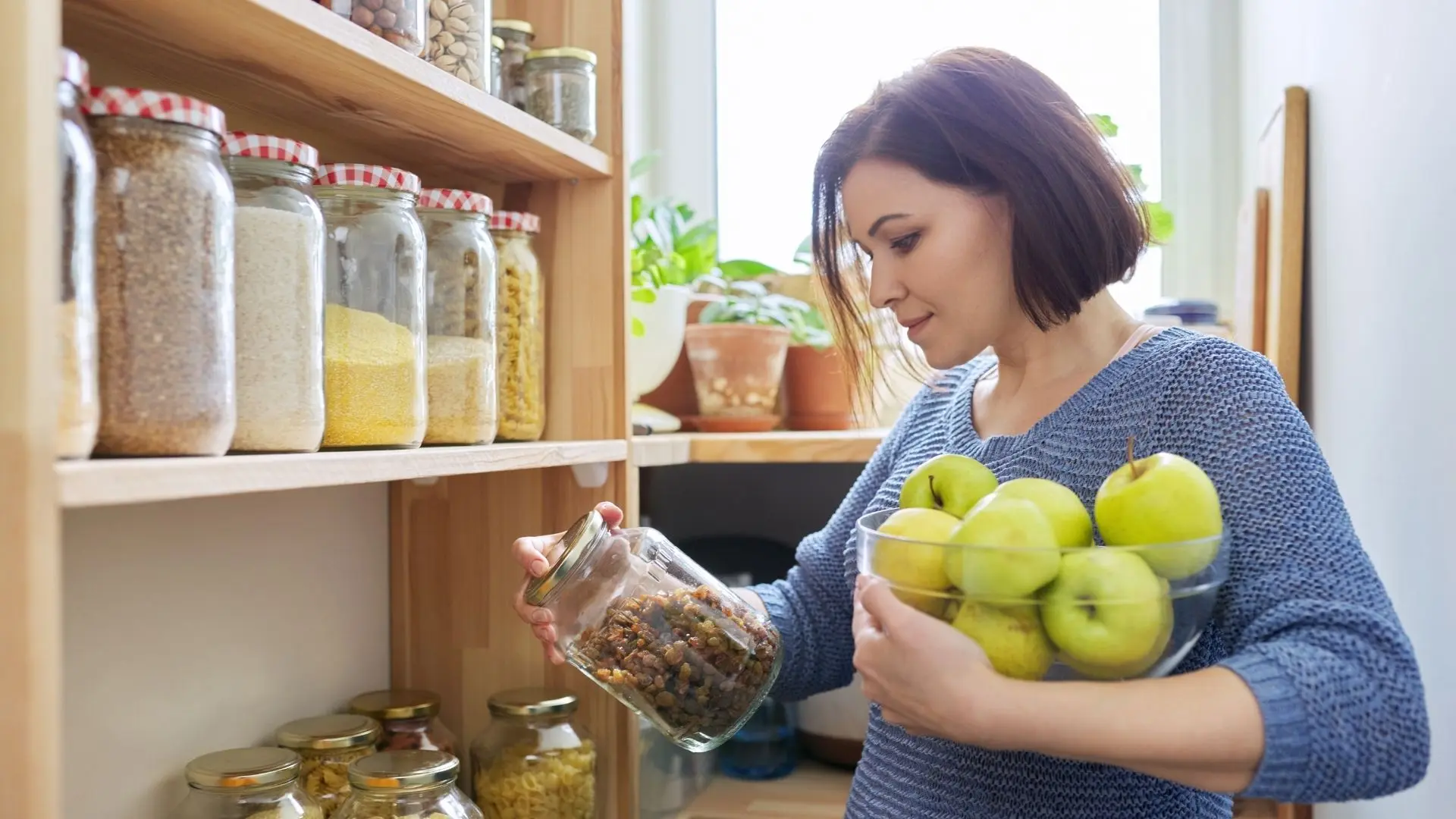woman carrying apples in kitchen